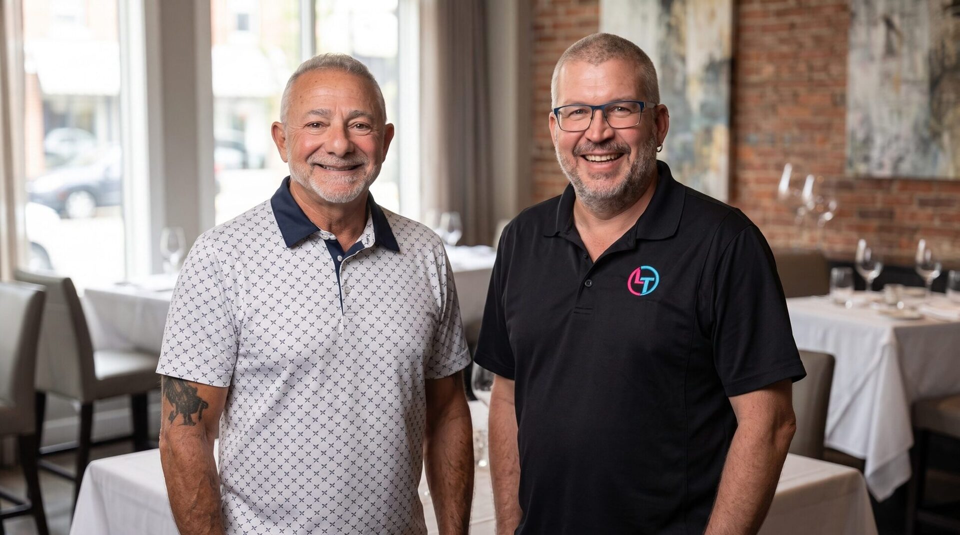 ABC Networks co-founders Christopher Brand and Dan standing together in a warm restaurant interior.